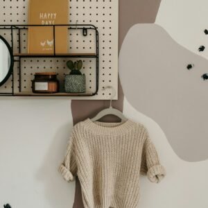 Pull enfant en maille beige présenté sur un mur clair