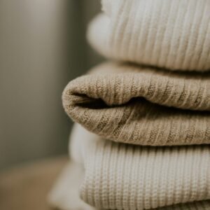 Pulls en maille écrue et beige soigneusement pliés